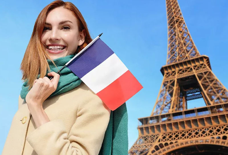 Девушка с французским флагом на фоне эйфелевой башне